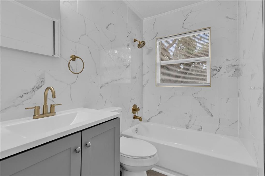 2307 Mispah Avenue, Unit A Leesburg, FL 34748 - Photo 9 of 25 a bathroom with a sink a toilet and shower