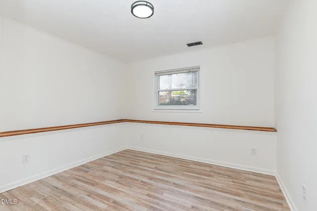 a view of an empty room with wooden floor