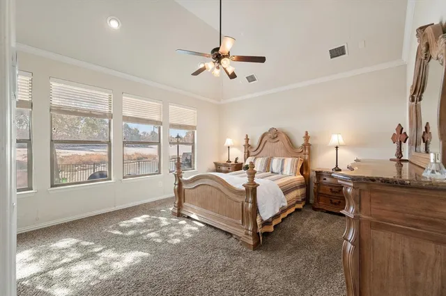a spacious bedroom with a bed a chandelier and large window