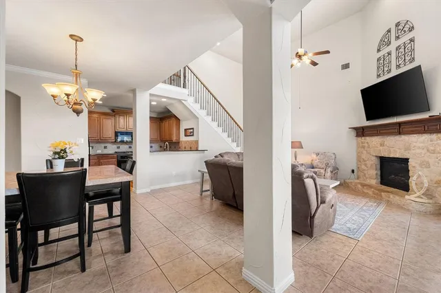 a view of a livingroom with furniture a fireplace wooden floor and a chandelier
