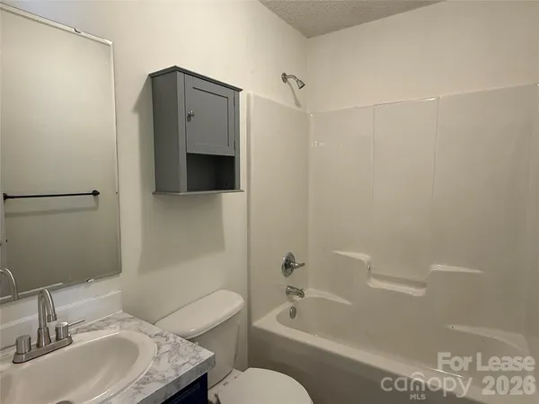 a bathroom with a granite countertop toilet sink and bathtub