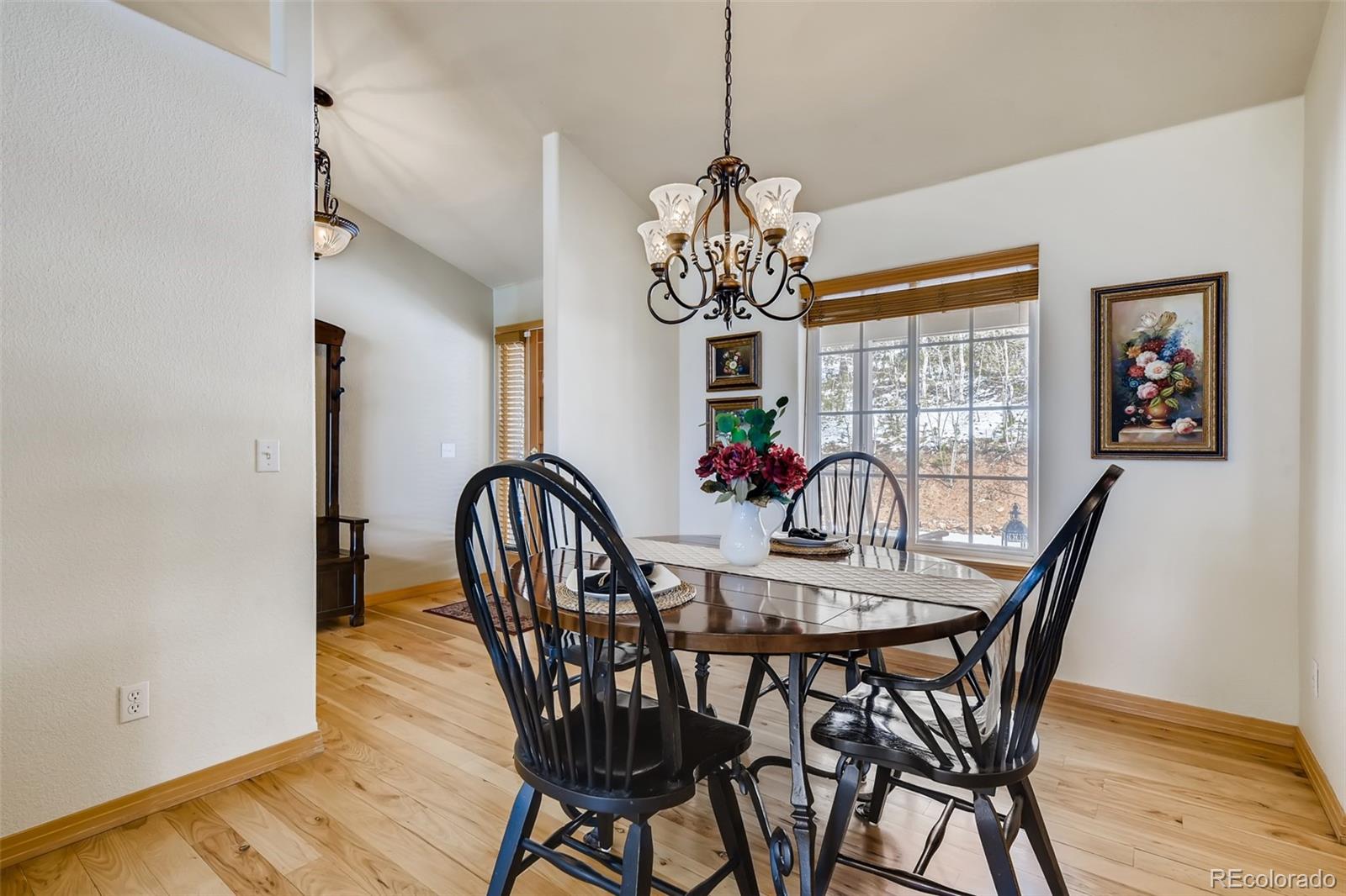 35681 Upper Aspen Lane Pine, CO 80470 - Photo 12 of 36 a view of a dining room with furniture wooden floor and chandelier