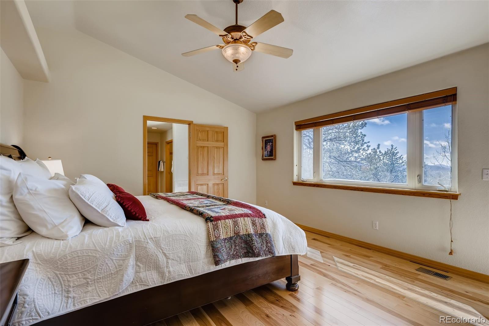 35681 Upper Aspen Lane Pine, CO 80470 - Photo 13 of 36 a bedroom with a large bed and a chandelier