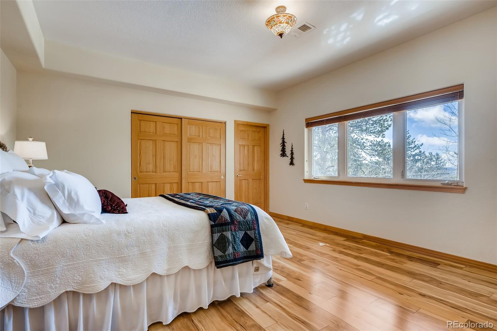 35681 Upper Aspen Lane Pine, CO 80470 - Photo 24 of 36 a bedroom with a bed and wooden floor