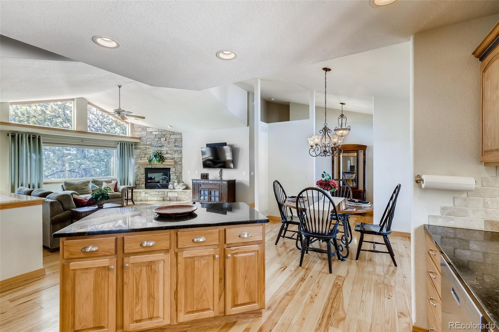 35681 Upper Aspen Lane Pine, CO 80470 - Photo 6 of 36 a room with stainless steel appliances kitchen island granite countertop a table chairs and a wooden cabinets