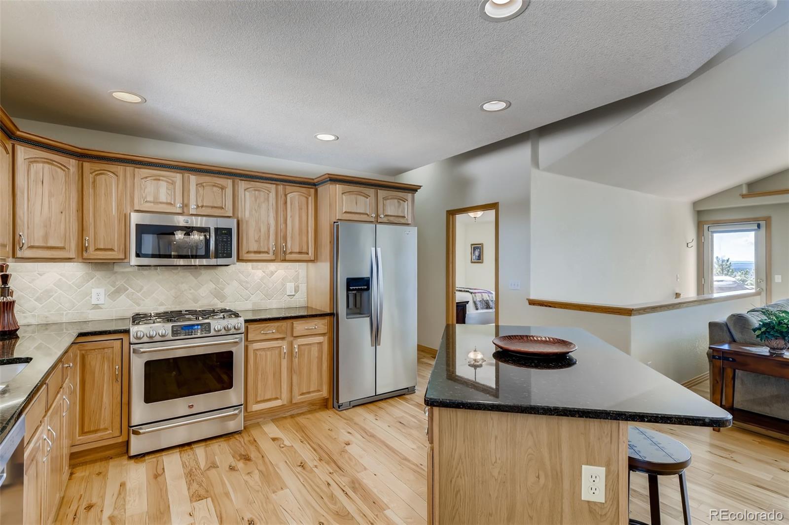 35681 Upper Aspen Lane Pine, CO 80470 - Photo 7 of 36 a kitchen with stainless steel appliances kitchen island granite countertop a stove a sink and a refrigerator