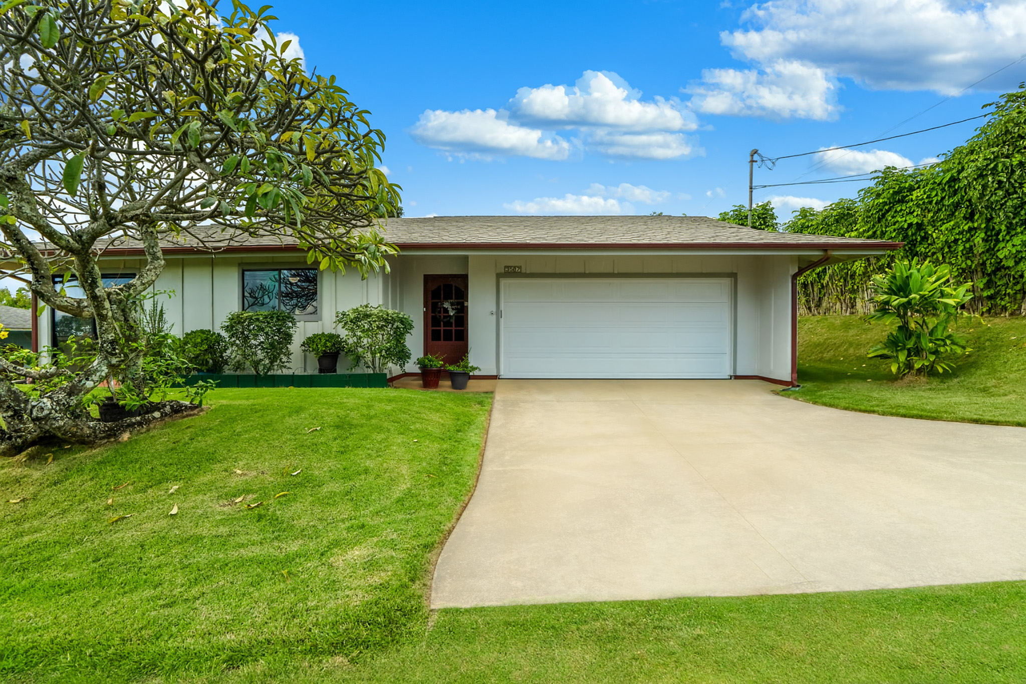 a front view of a house with a garden and yard