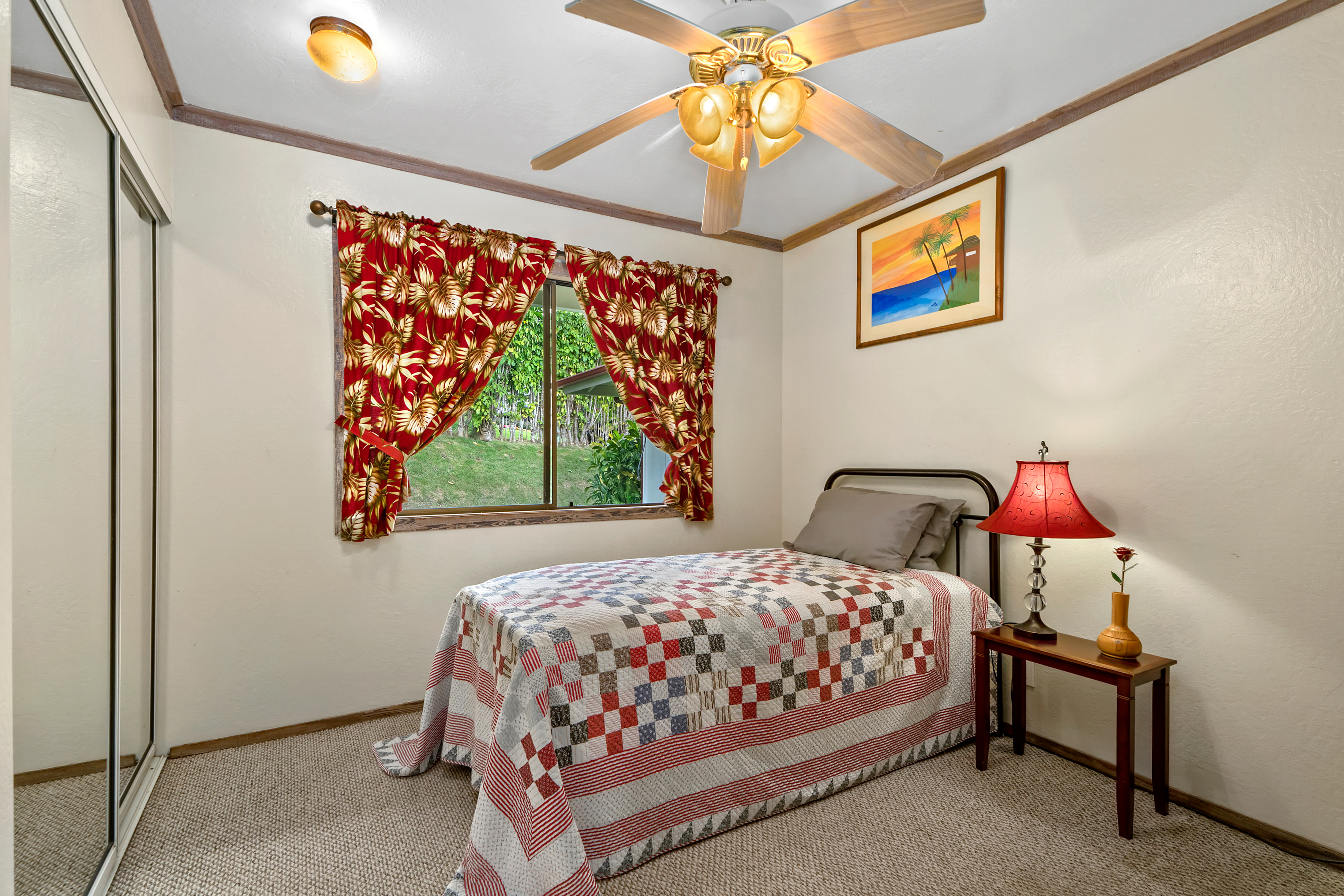 3587 Kaloke Street Kalaheo, HI 96741 - Photo 17 of 30 a bedroom with a bed and a chandelier