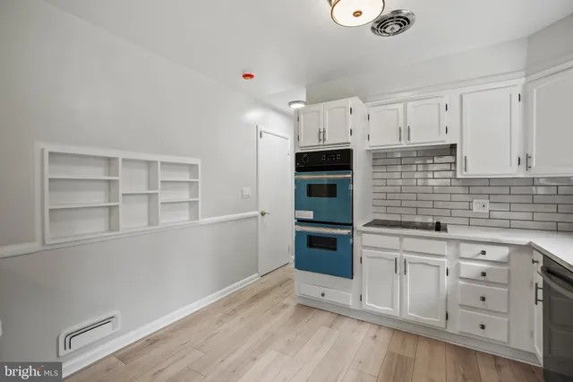 a kitchen with granite countertop white cabinets and stainless steel appliances