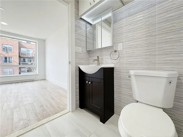 a bathroom with a toilet sink and mirror