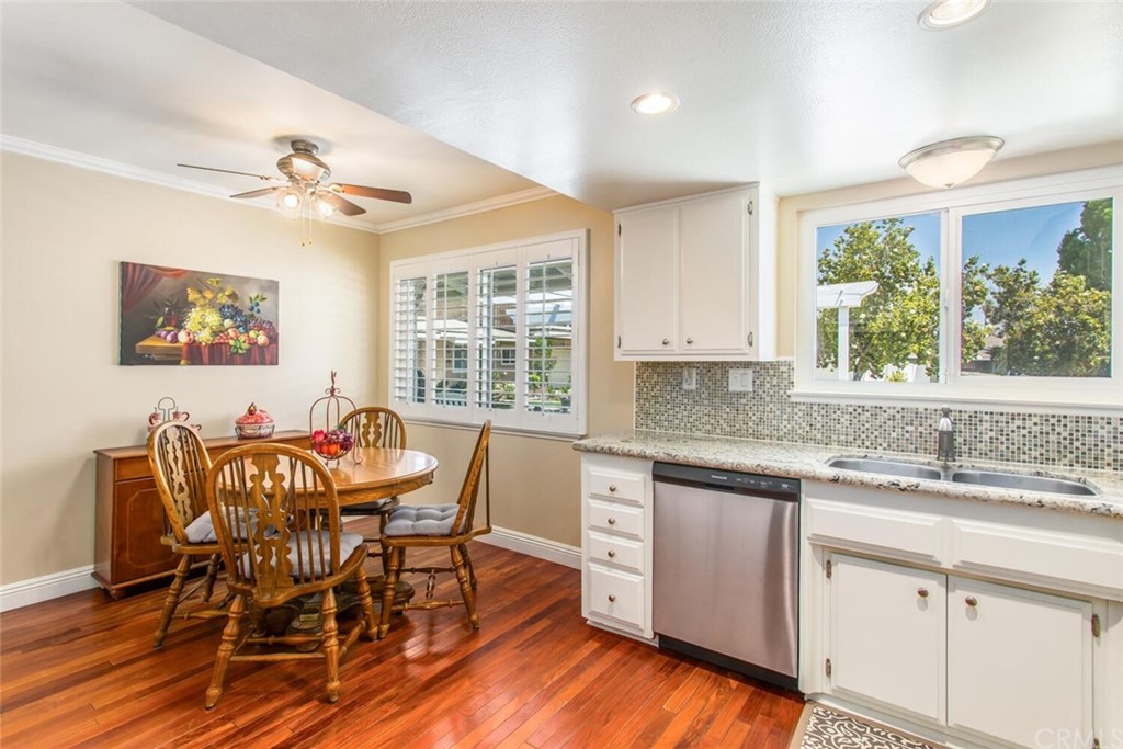 602 Juniper Court Redlands, CA 92374 - Photo 11 of 38 a kitchen with stainless steel appliances granite countertop a dining table chairs and white cabinets