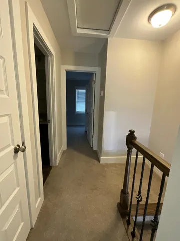 a view of a hallway with wooden floor and staircase