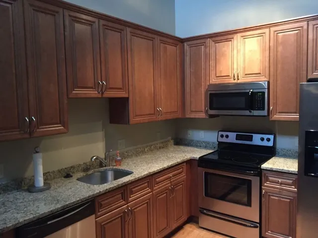 a kitchen with granite countertop a stove microwave and sink
