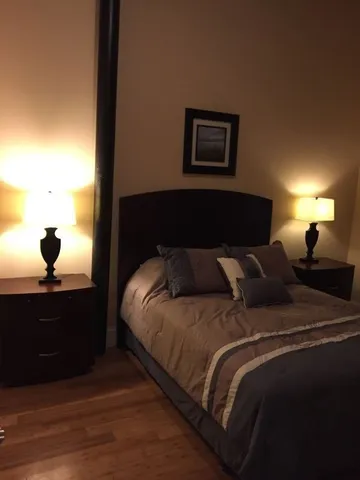 a bed sitting in a bedroom next to a lamp
