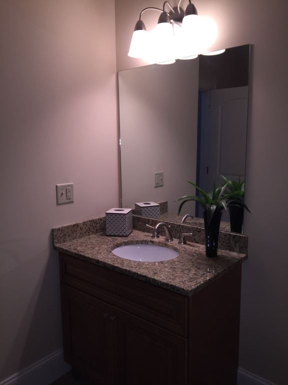 55 Green Street, Unit D147 Clinton, MA 01510 - Photo 9 of 21 a bathroom with a granite countertop sink a mirror and vanity