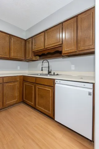 a kitchen with stainless steel appliances granite countertop a sink dishwasher stove and cabinets