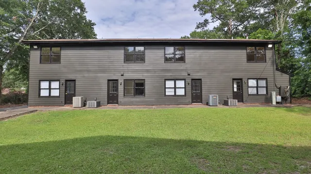 a brick house with a yard in front of it
