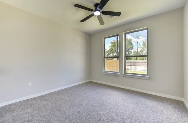 an empty room with a window and a fan