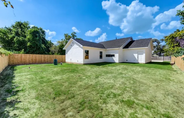 a view of a house with backyard and a tree
