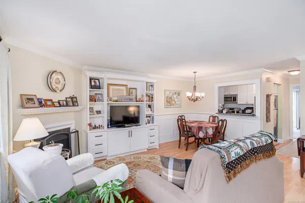 a living room with furniture a flat screen tv and kitchen view
