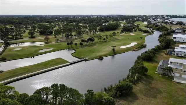 an aerial view of residential houses with outdoor space and lake view in back
