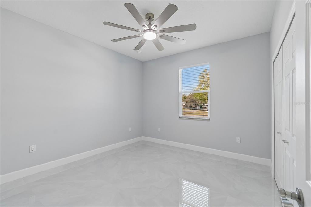 6018 Newmark Street Spring Hill, FL 34606 - Photo 11 of 26 an empty room with a window and a fan