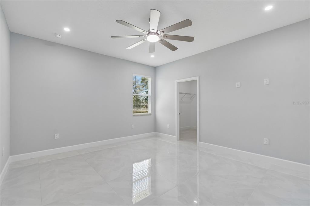 6018 Newmark Street Spring Hill, FL 34606 - Photo 14 of 26 an empty room with windows and fan
