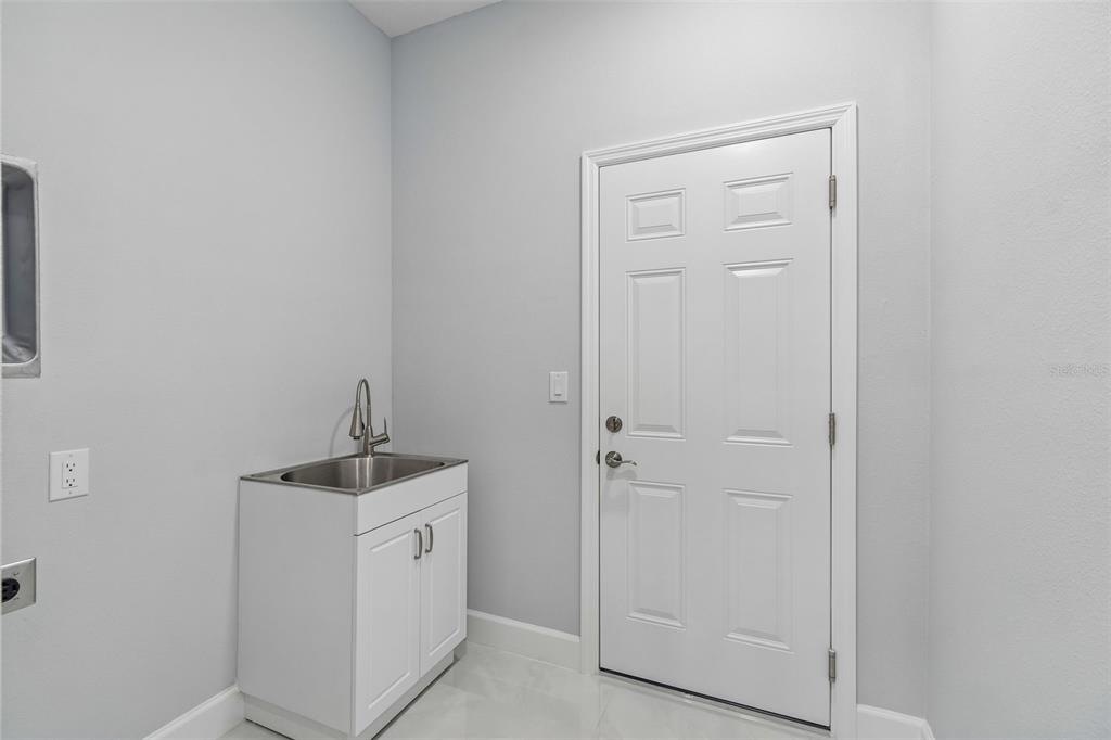 6018 Newmark Street Spring Hill, FL 34606 - Photo 16 of 26 a utility room with cabinets