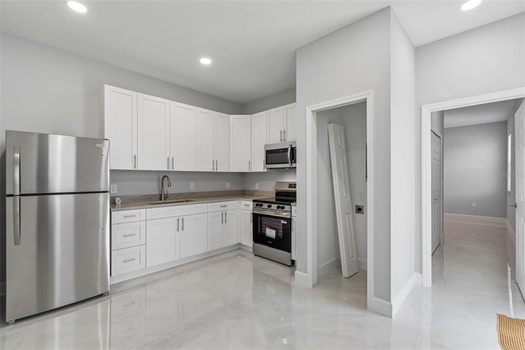 6018 Newmark Street Spring Hill, FL 34606 - Photo 21 of 26 a kitchen with stainless steel appliances granite countertop a refrigerator sink and stove