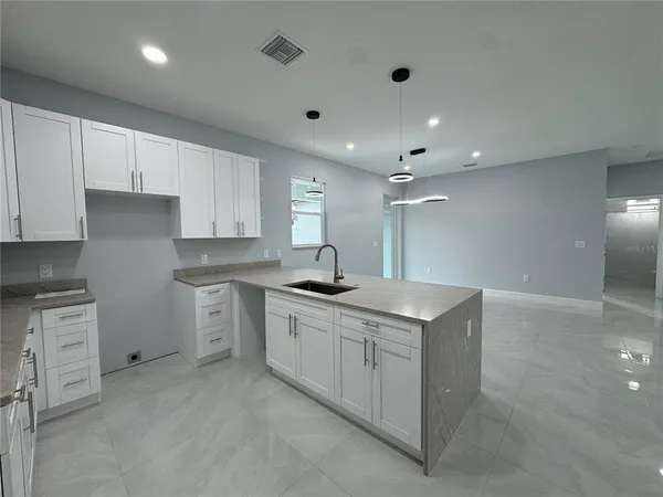 a kitchen with granite countertop a sink and cabinets