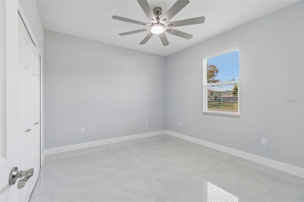 6018 Newmark Street Spring Hill, FL 34606 - Photo 8 of 26 an empty room with a window and a fan