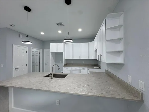 a kitchen with a sink refrigerator and cabinets