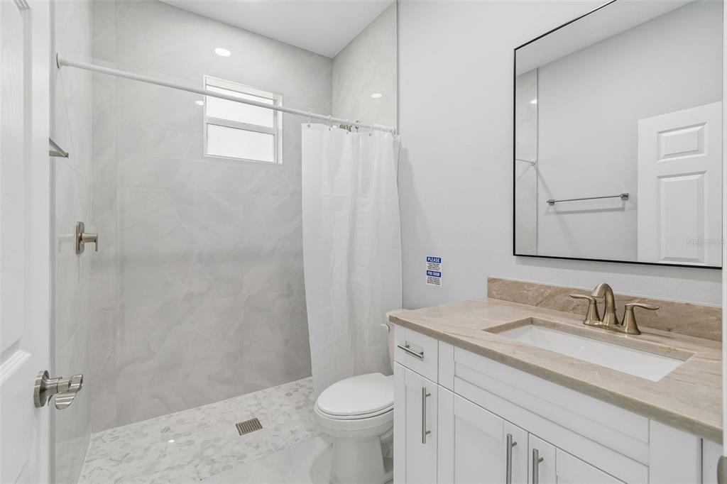 6018 Newmark Street Spring Hill, FL 34606 - Photo 10 of 26 a bathroom with a sink toilet vanity and shower