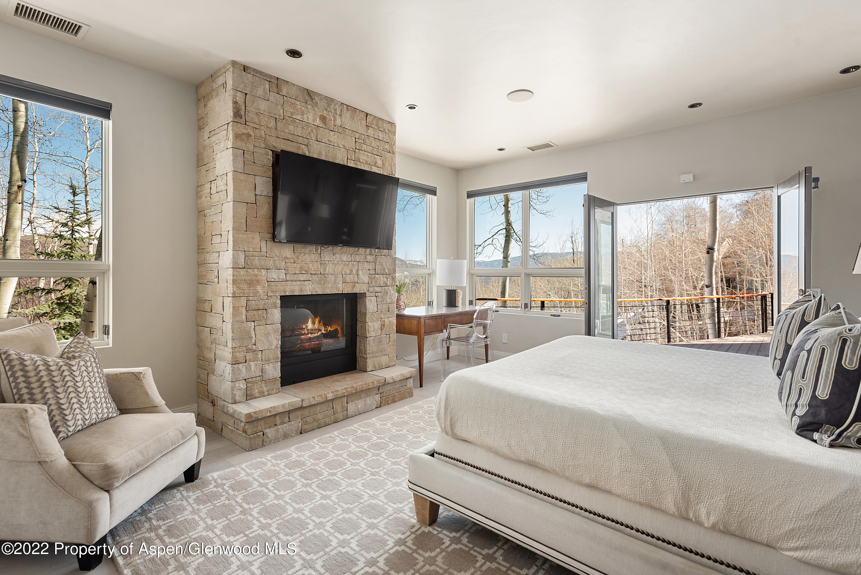 399 Maple Ridge Lane Snowmass Village, CO 81615 - Photo 10 of 27 a bedroom with a bed and a fireplace