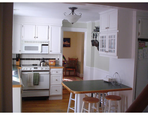 85 Gleason Road Lexington, MA 02420 - Photo 5 of 10 a kitchen with stainless steel appliances granite countertop a stove a refrigerator a sink a dining table and chairs