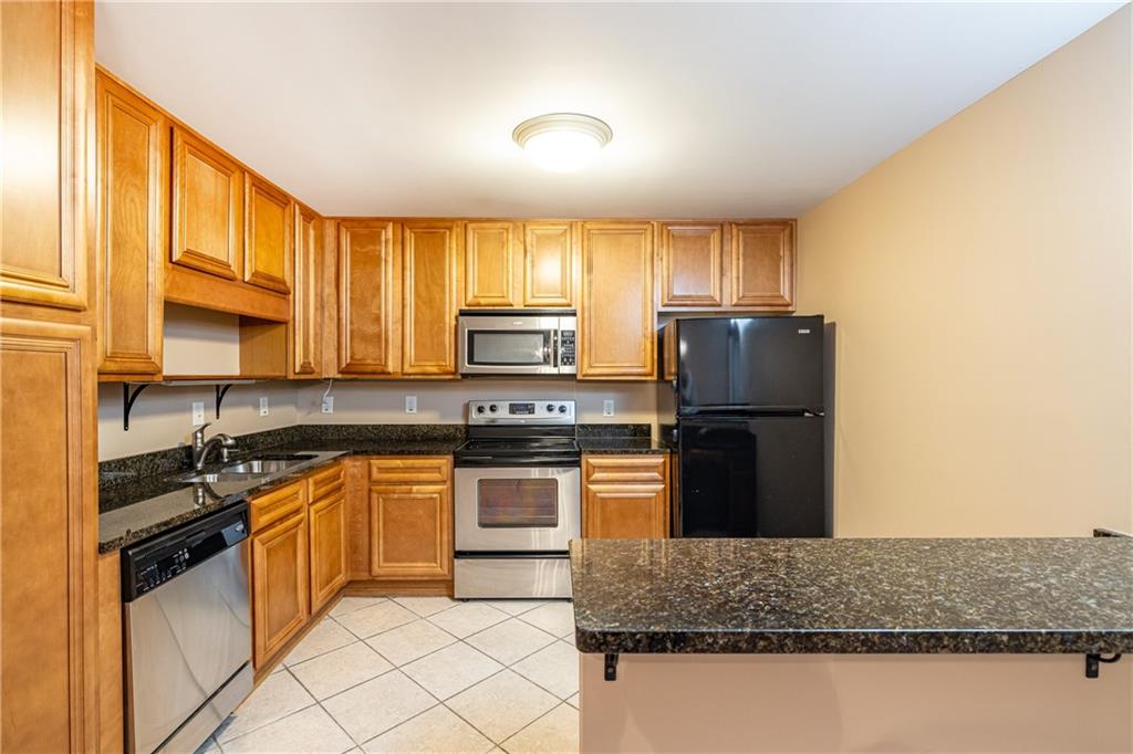 1468 Briarwood Road Northeast, Unit 1005 Atlanta, GA 30319 - Photo 11 of 45 a kitchen with kitchen island granite countertop white cabinets and refrigerator