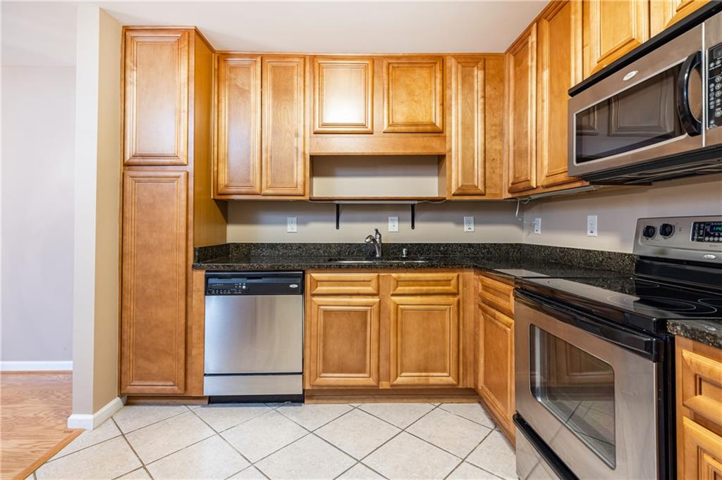 1468 Briarwood Road Northeast, Unit 1005 Atlanta, GA 30319 - Photo 13 of 45 a kitchen with stainless steel appliances granite countertop a stove a sink and a microwave
