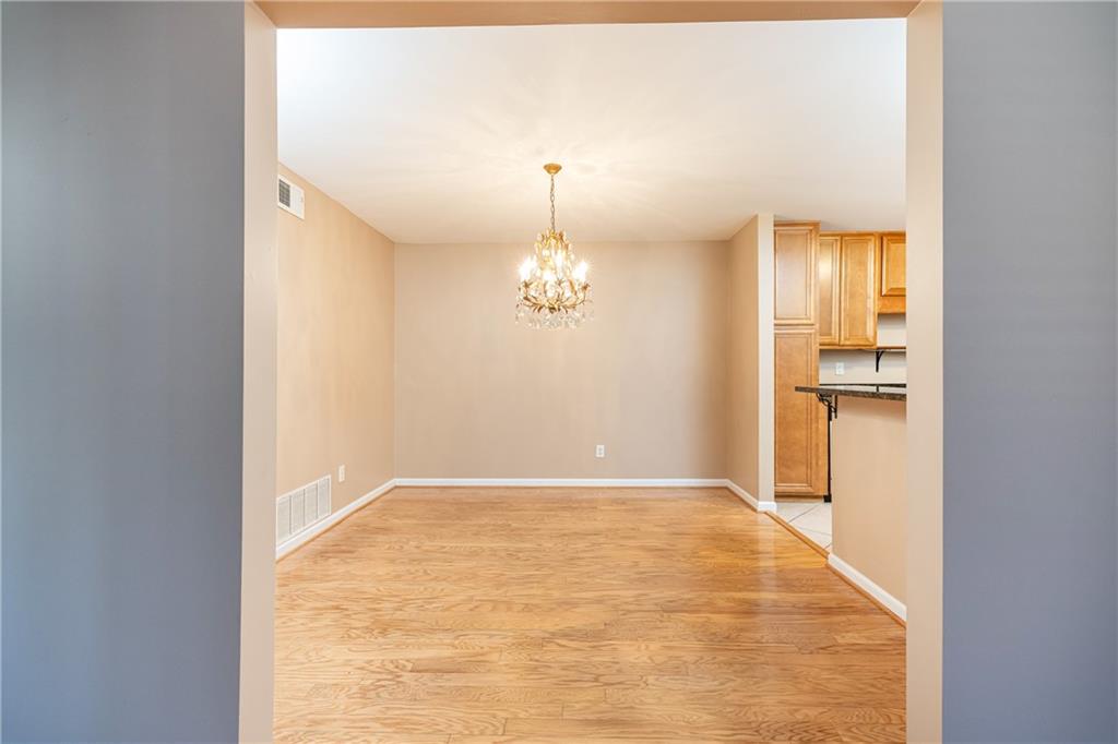 1468 Briarwood Road Northeast, Unit 1005 Atlanta, GA 30319 - Photo 21 of 45 an empty room with chandelier fan and kitchen view