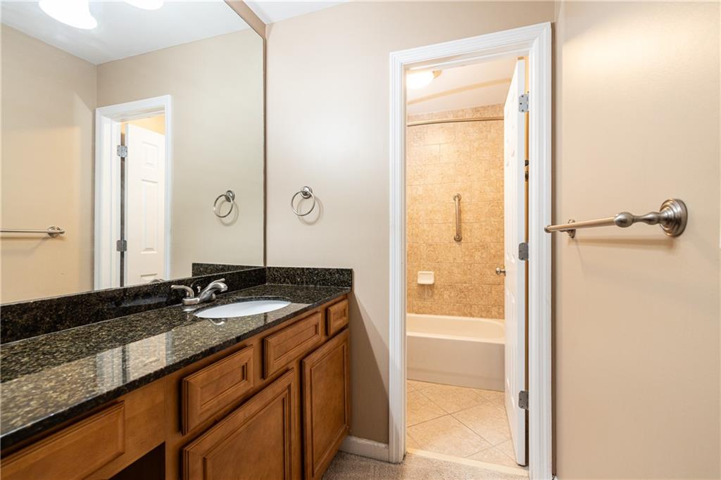 1468 Briarwood Road Northeast, Unit 1005 Atlanta, GA 30319 - Photo 28 of 45 a bathroom with a granite countertop sink and a mirror