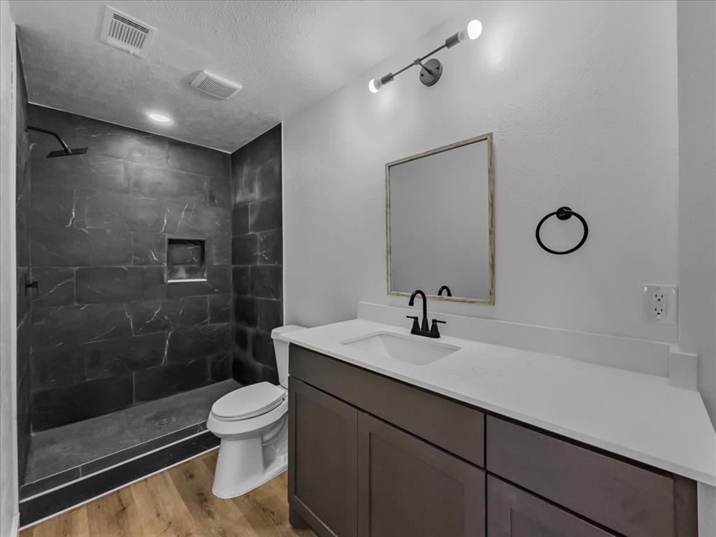 a bathroom with a sink a toilet and shower