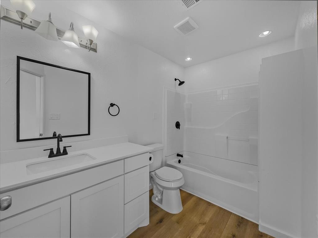 1236 Harrison Lane Hurst, TX 76053 - Photo 24 of 25 a bathroom with a sink a toilet a mirror and shower