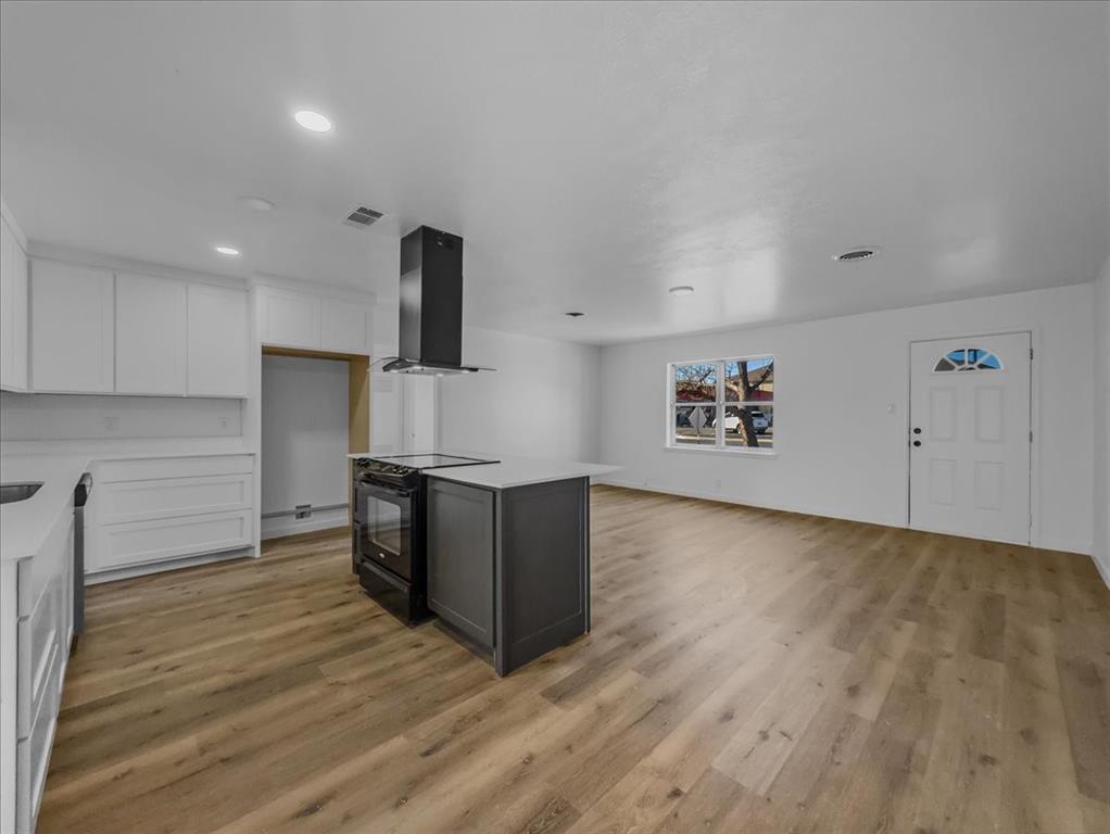 1236 Harrison Lane Hurst, TX 76053 - Photo 3 of 25 a kitchen with granite countertop a stove and a wooden floors