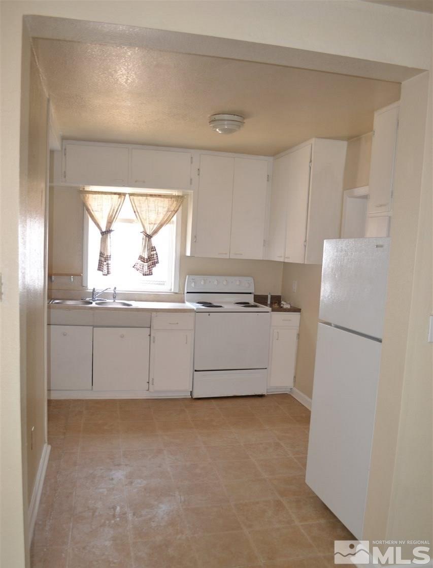 1395 Terrace Drive Reno, NV 89503 - Photo 2 of 7 a kitchen with white cabinets and window