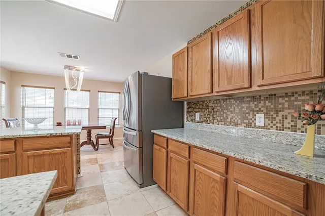 a kitchen with stainless steel appliances granite countertop a stove refrigerator sink and cabinets