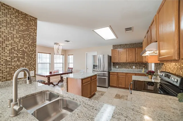 a kitchen with stainless steel appliances granite countertop a sink stove and cabinets