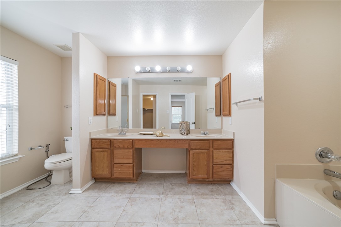 11228 Pickard Lane Austin, TX 78748 - Photo 25 of 32 a spacious bathroom with a bathtub sink and toilet