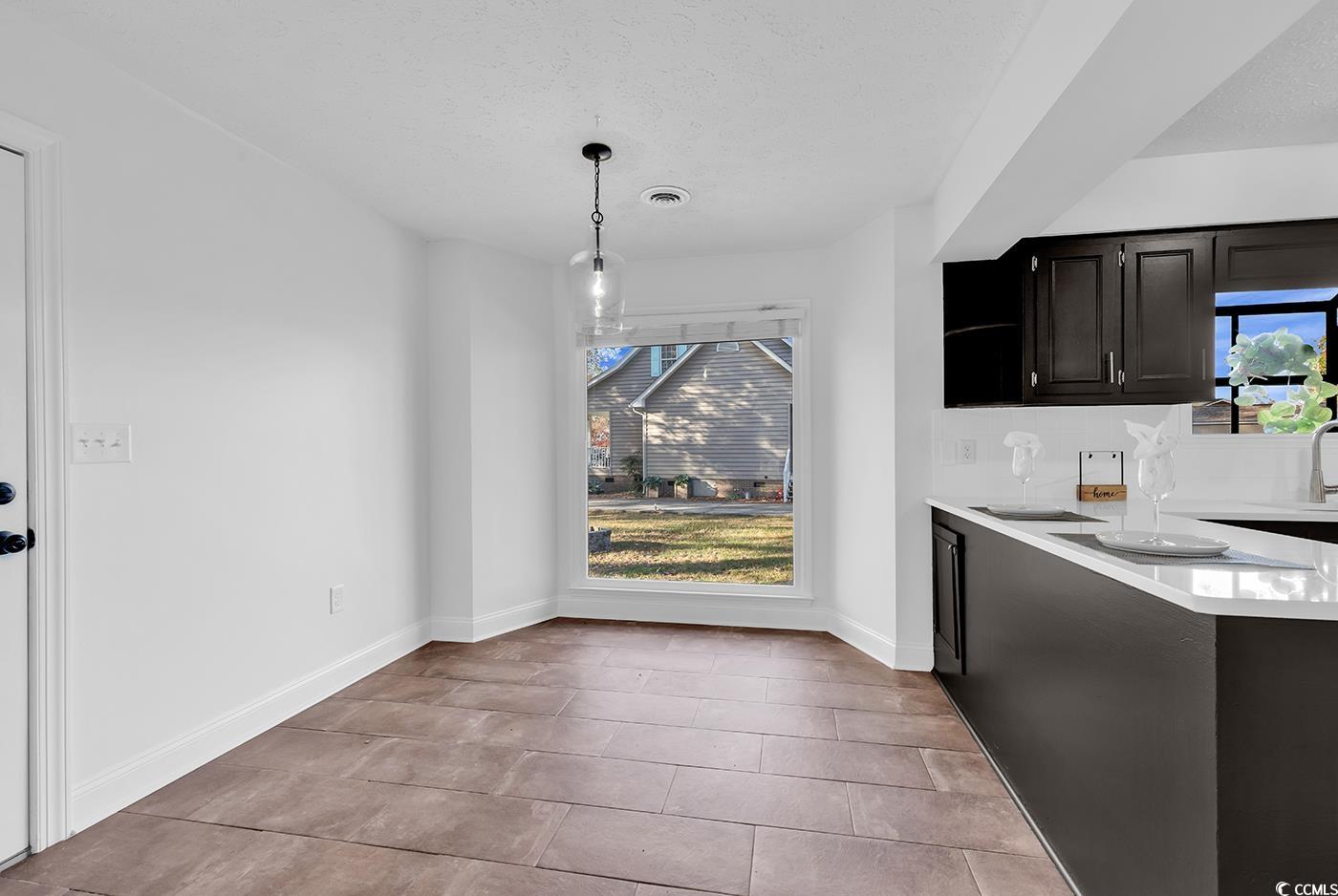 506 Merrywood Drive Conway, SC 29526 - Photo 14 of 40 Unfurnished dining area with plenty of natural light, a textured ceiling, and light tile patterned flooring