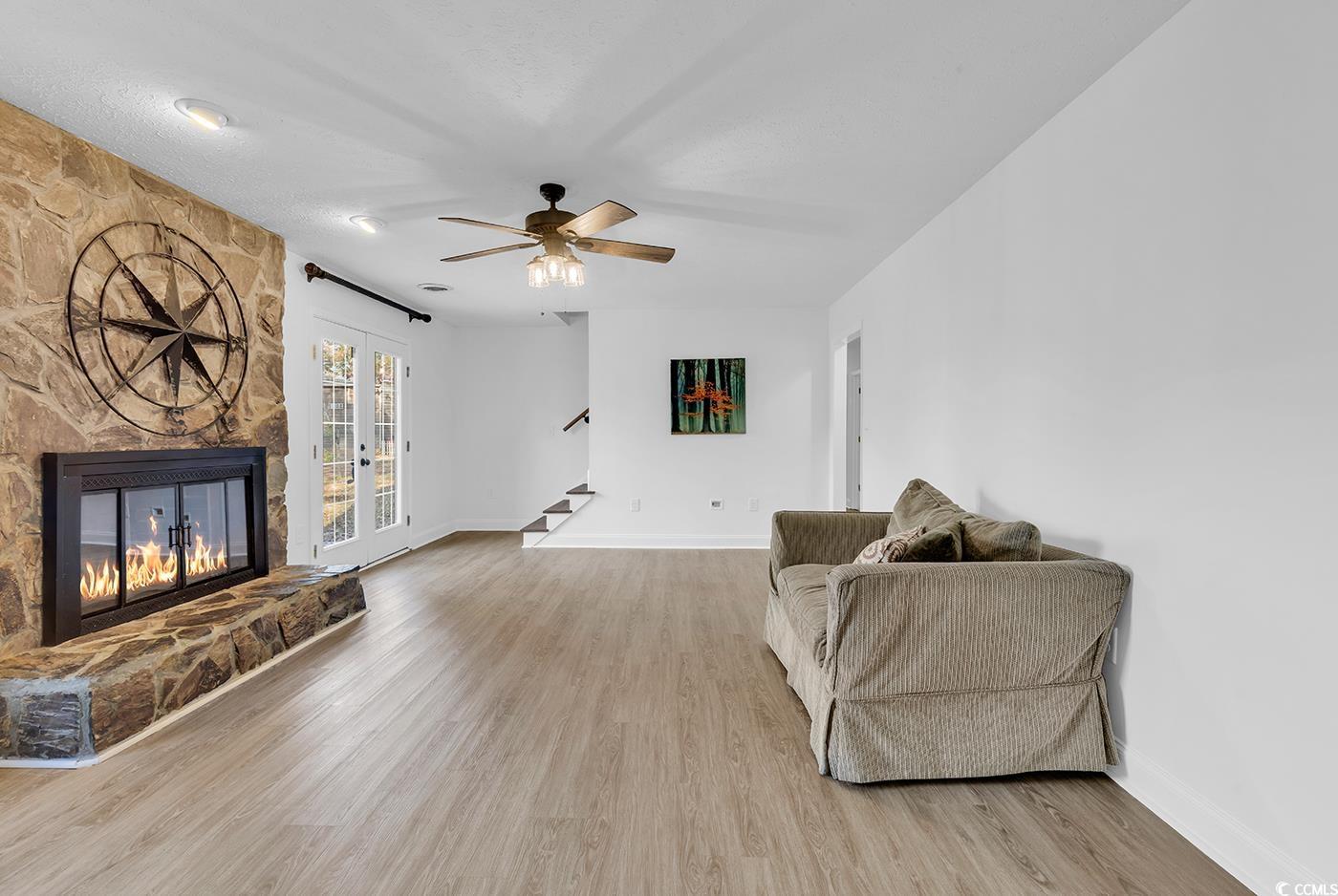 506 Merrywood Drive Conway, SC 29526 - Photo 17 of 40 Living area with stairway, a fireplace, light wood-style flooring, french doors, and a textured ceiling