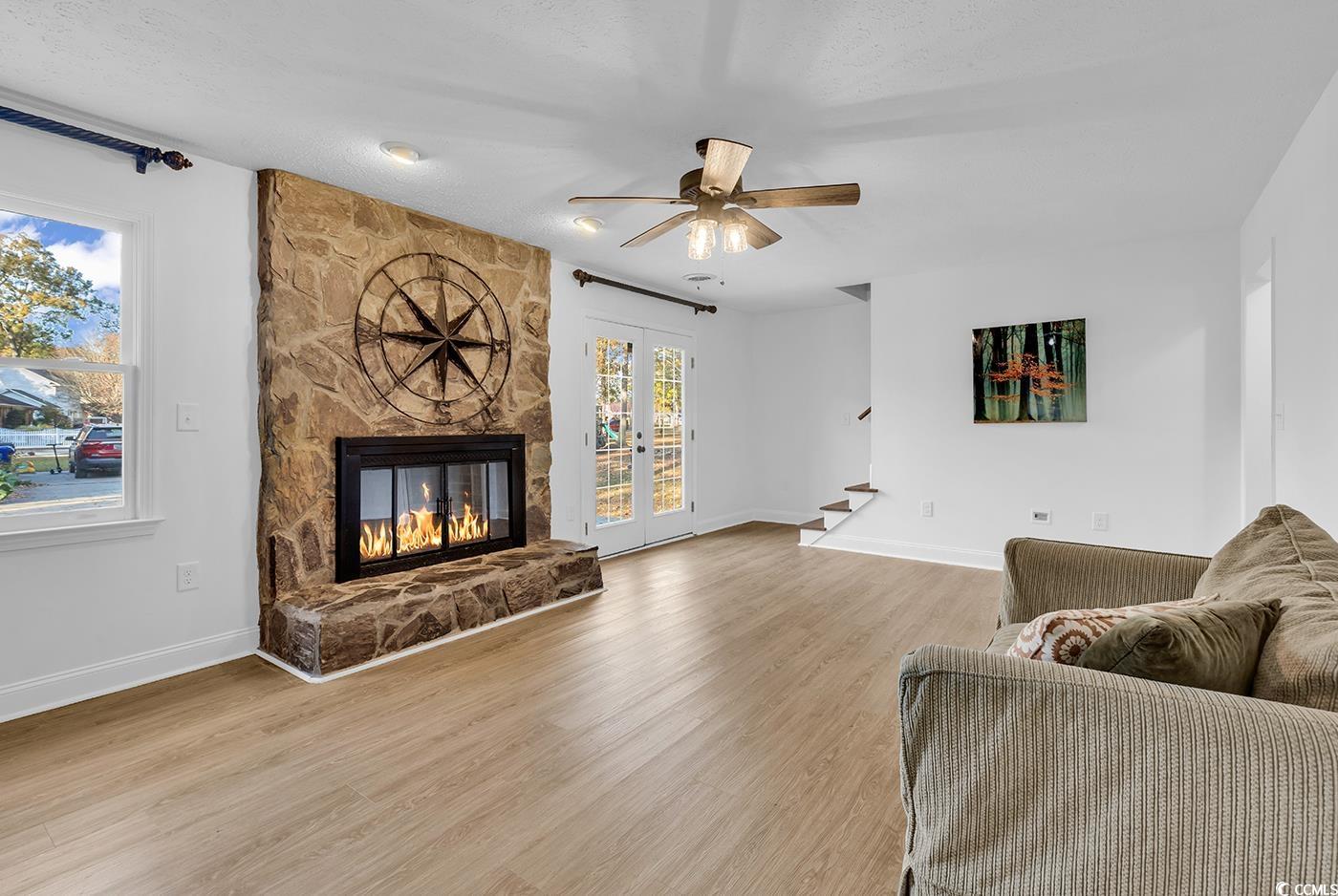 506 Merrywood Drive Conway, SC 29526 - Photo 18 of 40 Living area with stairs, a stone fireplace, french doors, light wood finished floors, and a textured ceiling