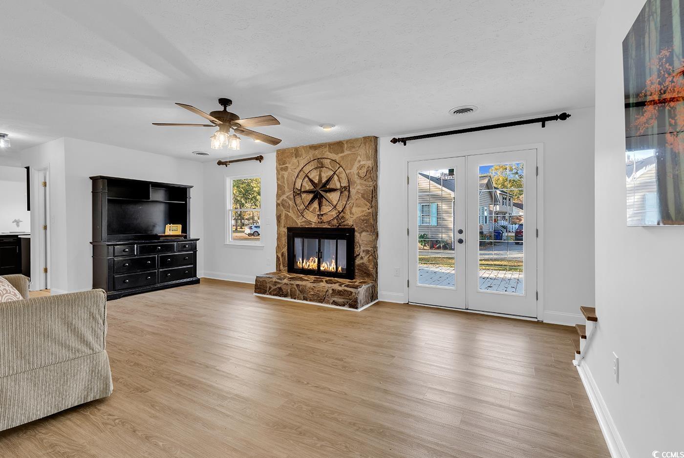 506 Merrywood Drive Conway, SC 29526 - Photo 19 of 40 Unfurnished living room featuring a fireplace, light wood finished floors, french doors, ceiling fan, and a textured ceiling